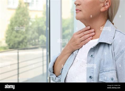 Mature Woman Doing Thyroid Self Examination Near Window Closeup Space