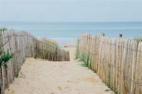 chemin menant à la plage avec une clôture et du sable d une dune Stock