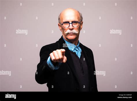 Confident Mature Man In Formalwear Pointing You While Standing Against