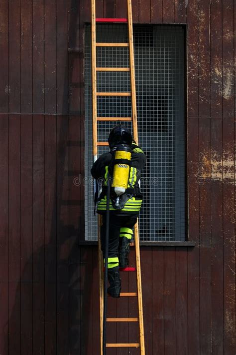Firefighter Climbing A Ladder With An Oxygen Tank Stock Image Image