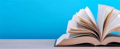 O Livro Esta Sob A Mesa - O livro está aberto, deitado sobre a mesa, com folhas espalhadas sobre ...