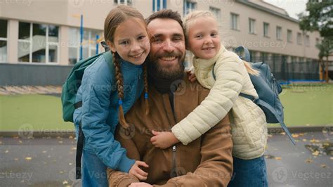 Close up European man little girls father and daughters hug sisters