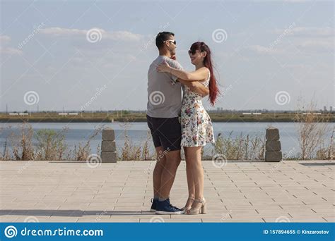 Happy Loving Couple Embracing And Kissing Outdoors At Summertime Under