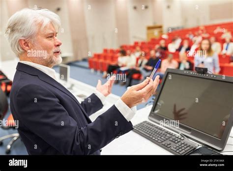 Mature Male Speaker Gesturing At Stage While Discussing In Business