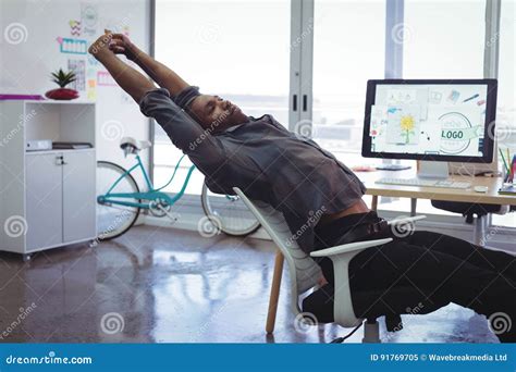 Businessman Stretching on Chair in Creative Office Stock Image - Image ...