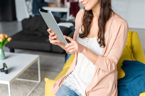 Plano Medio De La Mujer Que Usa Una Tableta En El Interior Foto Gratis