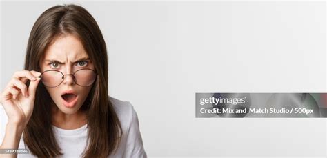 Closeup Of Insulted And Shocked Young Angry Woman Looking From Under