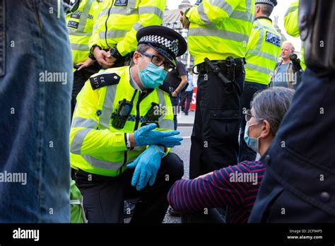 A Police Officer Talks To Protester Blocking Road During Extinction