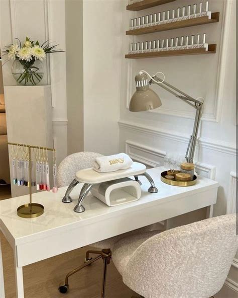 A White Desk Topped With A Chair Next To A Shelf Filled With Bottles