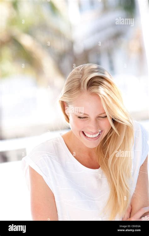 Female With Long Straight Blonde Hair Wearing A White Top Smiling