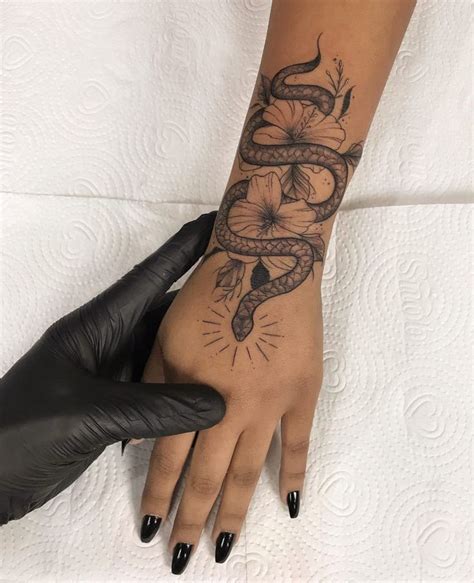 A Woman S Hand With A Tattoo On It And A Snake Wrapped Around The Wrist