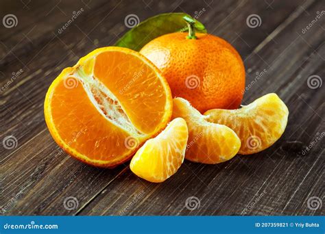 Ripe Mandarin Fruit Peeled Open And Place On Old Rustic Look Timber