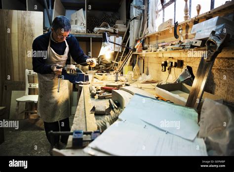 Man Standing At A Work Bench In A Carpentry Workshop Working On A