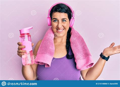 Plus Size Brunette Woman Wearing Sportswear Holding Water Bottle Celebrating Achievement With