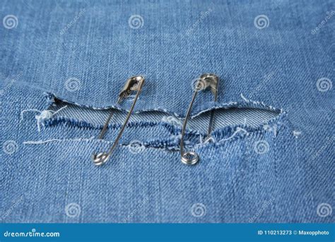 Hole In Blue Jeans Fixed With Safety Pins Stock Image Image Of Pins