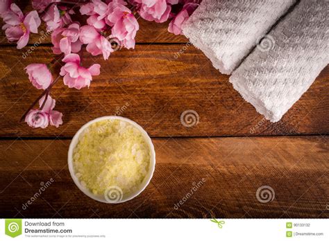 Wellness Setting Sea Salt In Bowl Towel And Flowers On Brown T Stock