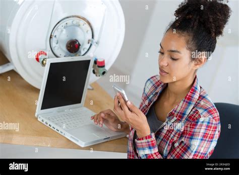 Female Plumber Checking How To Fix A Boiler Stock Photo Alamy