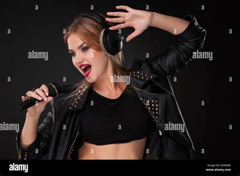 Portrait Of A Beautiful Woman Singing Into Microphone With Headphones