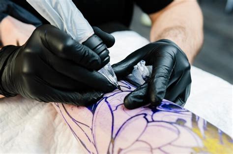 Premium Photo Professional Tattoo Artist Makes A Tattoo On The Male Leg