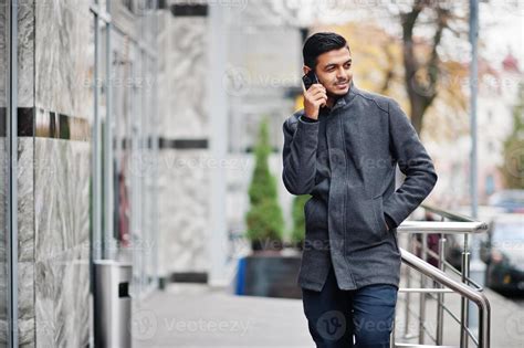 Stylish Indian Hindu Man In Gray Coat Posed On Street And Speaking At