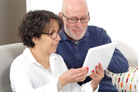 Premium Photo Senior Couple Using Digital Tablet While Sitting On