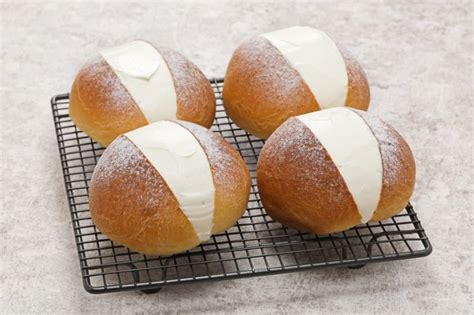 Three Loaves Of Bread With White Icing On A Cooling Rack In The Kitchen