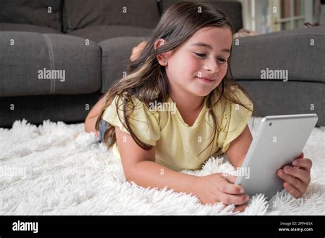 Niña linda ver dibujos animados en tableta digital El niño se acuesta