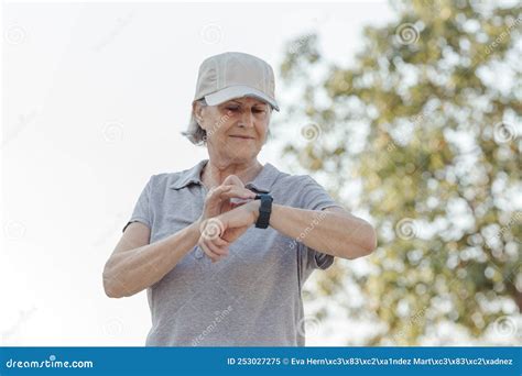 Une Femme De Ans Regarde Sa Montre De Sport En Plein Air Image Stock