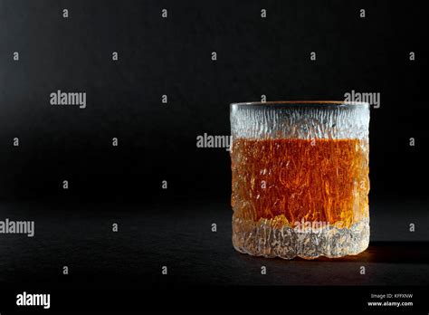 A Glass Of Neat Malt Scotch Whiskey Over Testured Black Backdrop Stock