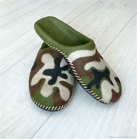 a pair of camouflage slippers sitting on top of a white wooden floor ...