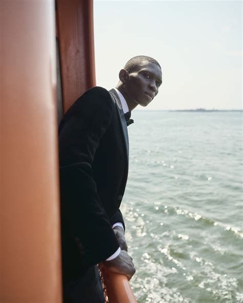 A Man In A Tuxedo Standing On The Edge Of A Boat Looking Out At The Water