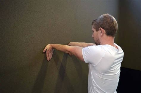 A Man Leaning Against A Wall With His Hand On The Wall