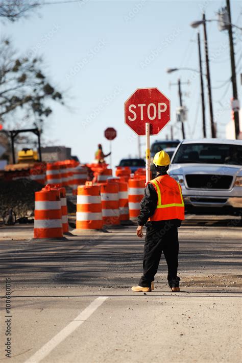 Worker Holding Stop Sign In Construction Site On The Street Stock Photo