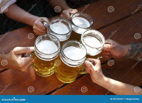 People Drinking Beer In A Traditional Bavarian Beer Garden Stock Image