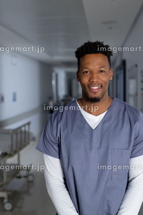 Portrait Of Happy African American Male Doctor Wearing Scrubs In