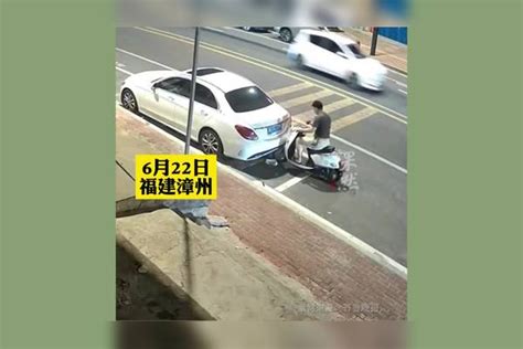 男子骑车看手机撞上路边小车头部，伤后首先看手机再摸伤口。