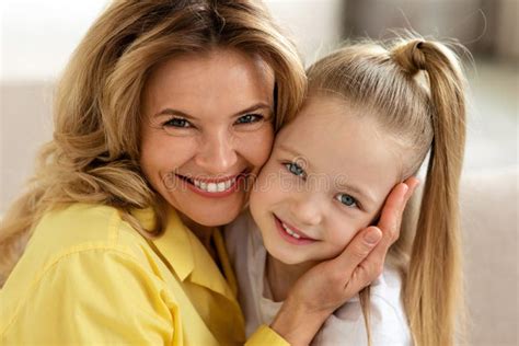 Retrato De Madre De Mediana Edad Y Pequeña Hija Abrazándose Bajo Techo