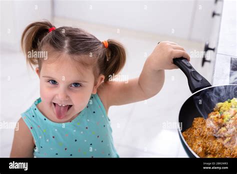 Jolie Fille Souriante Petite Fille Jouant Avec Sex Plat De Cuisson Dans La Cuisine Photo Stock
