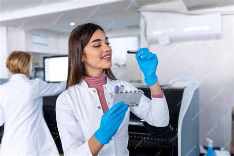 Asistente De Laboratorio Poniendo Tubos De Ensayo En El Soporte Médico