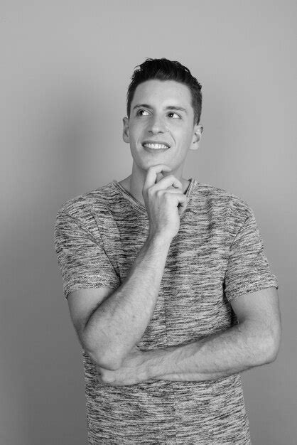 Foto De Estudio De Joven Apuesto Hombre Vestido Con Camisa Gris Contra