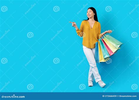 Smiling Young Korean Lady In Casual Shopaholic Showing Free Space Stock