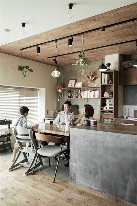 Two People Sitting At A Table With Laptops In Front Of Them And Shelves