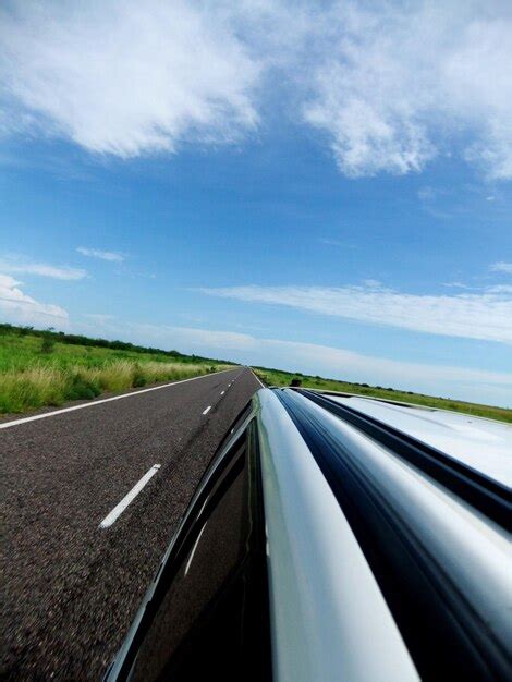 Premium Photo Car Moving On Road Against Blue Sky