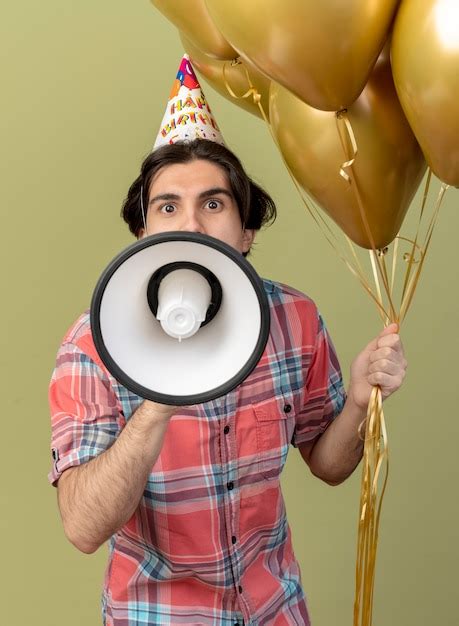 Impresionado apuesto hombre caucásico vestido con gorro de cumpleaños