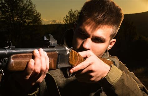 Chasseur De Fusil Silhouetté Dans Un Beau Coucher De Soleil Chasseur à