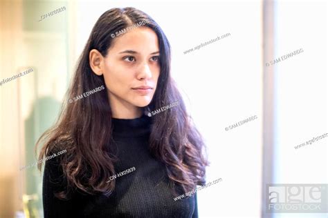 Serious Brunette Woman Looking At Reflection In Bathroom Mirror Stock