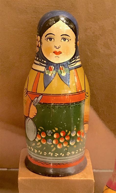 A Ceramic Figurine Sitting On Top Of A Wooden Stand Next To A Wall