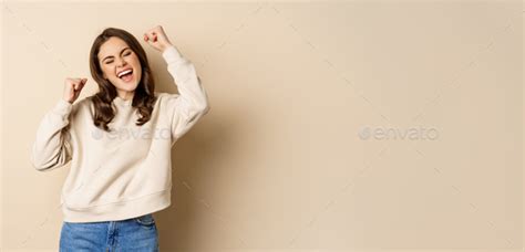 Enthusiastic Brunette Woman Laughing And Smiling Cheering Shaking