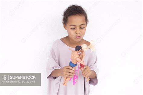 Girl Making Dolls Kiss Each Other Superstock