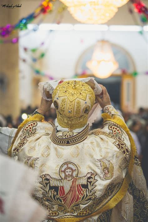 A Man In A Priest S Outfit With His Hands On His Head